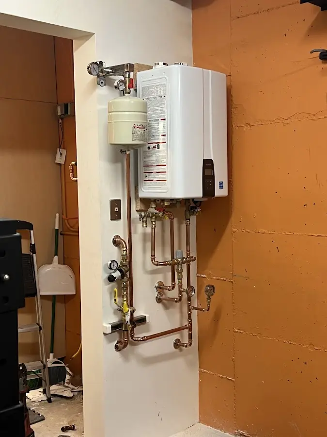 Plumbing technician inspecting water heater connections in Cornelia